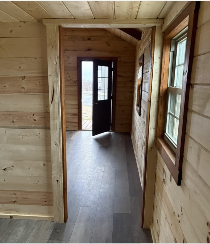Rustic log cabin entryway with natural wood walls and modern flooring